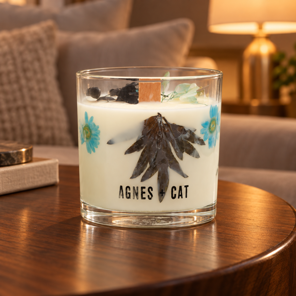Agnes + Cat Botanical Sojawachskerze Sea Salt & Moss mit Trockenblüten im Glas auf einem Holztisch im Wohnzimmer