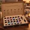 Geöffnetes Aromatherapie-Duftset Herbst mit zwölf Ölflaschen und zwei Pipetten auf einem Holztisch in einer warm beleuchteten Wohnszene