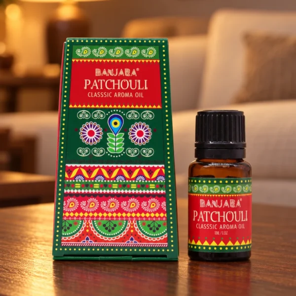 Banjara Duftöl Patchouli · 10 ml in einer warm beleuchteten Wohnszene auf dunklem Holz.
