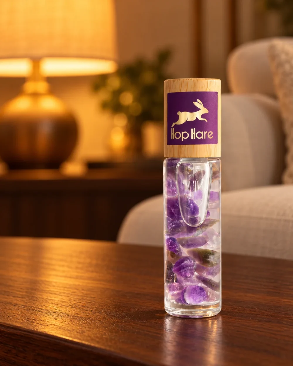 Hop Hare Edelstein-Roll-on The Moon · Amethyst in einer warm beleuchteten Wohnszene auf dunklem Holz.