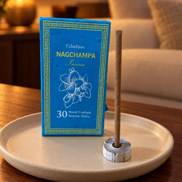 Sughandit Dhoop Räucherstäbchen Nag Champa · 30 Stück in einer warm beleuchteten Wohnszene auf dunklem Holz.
